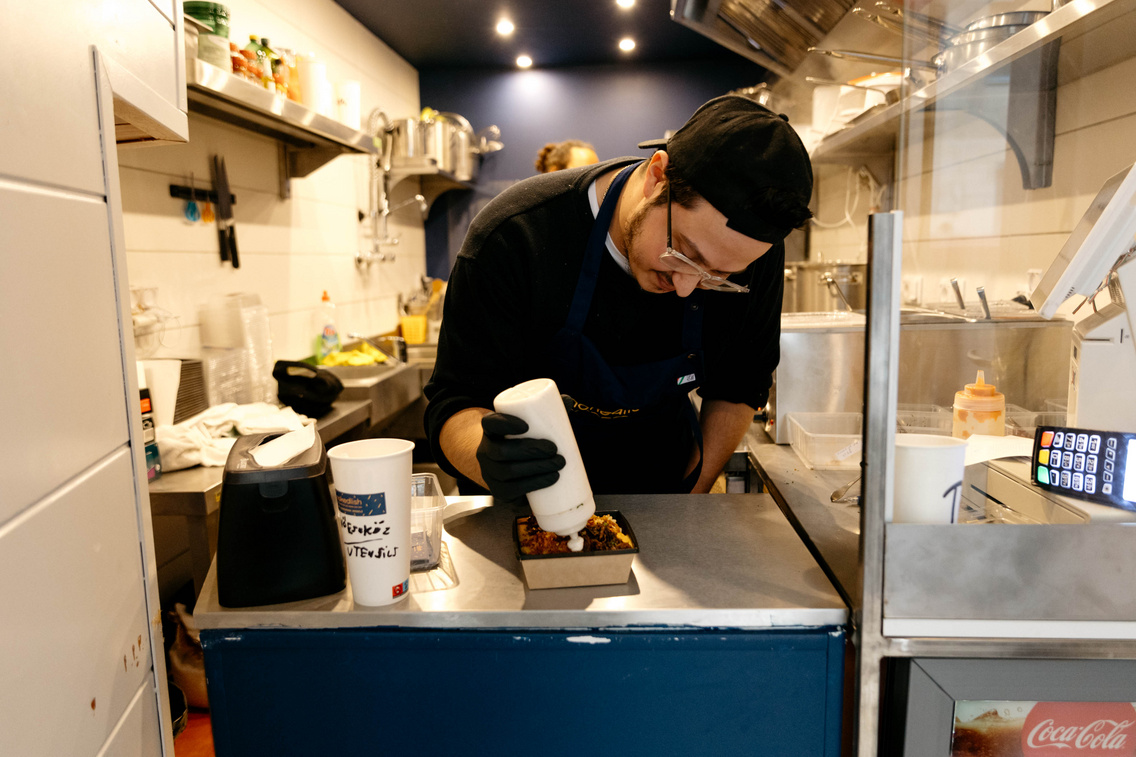 Nokedlish chef carefully finishing a dish in the kitchen
